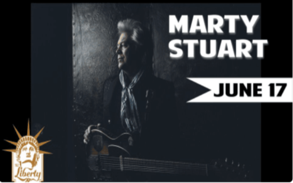 Photo of Marty Stuart holding a guitar